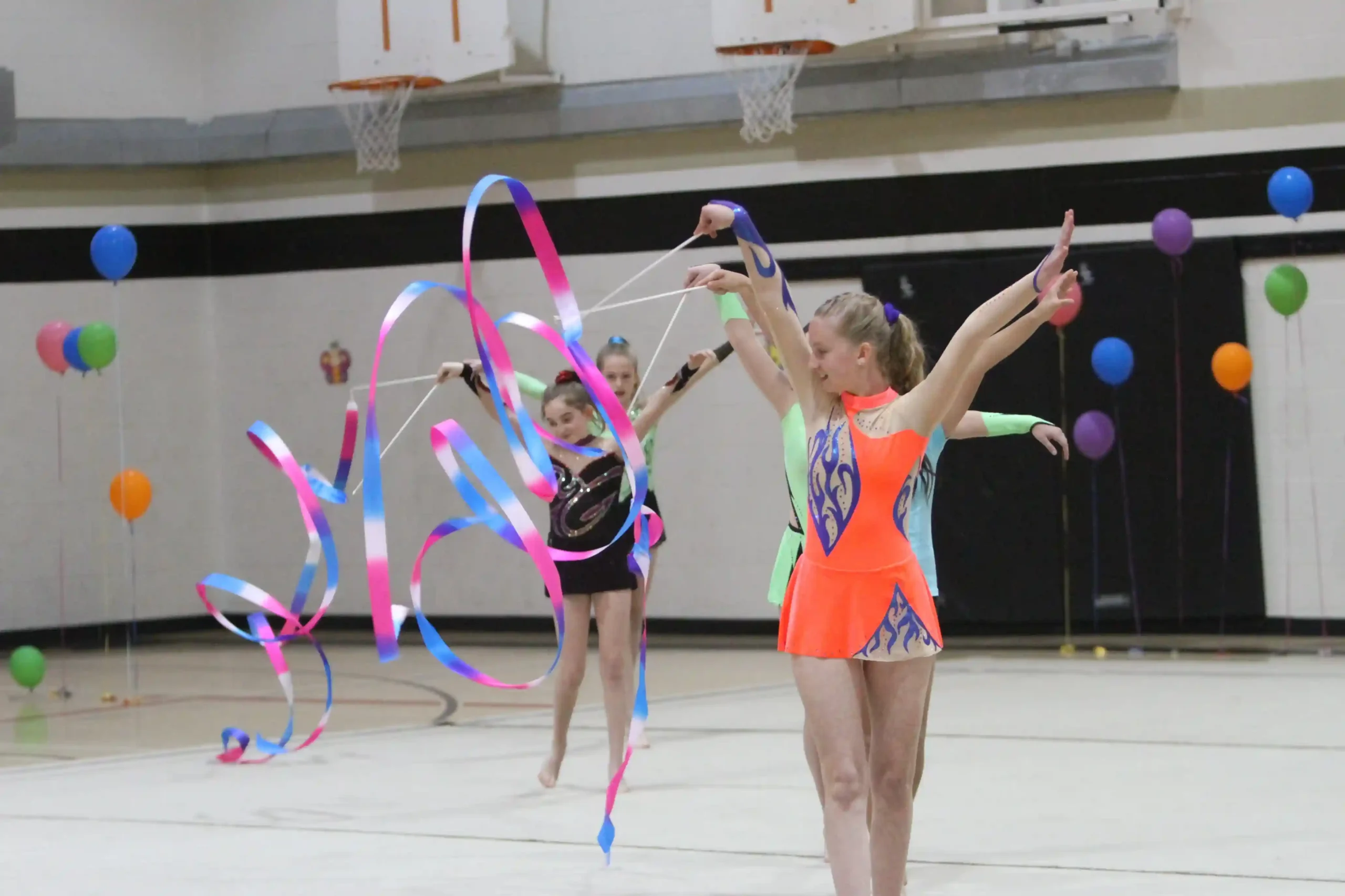 Gymnasts performing a ribbon routine at the club gala.